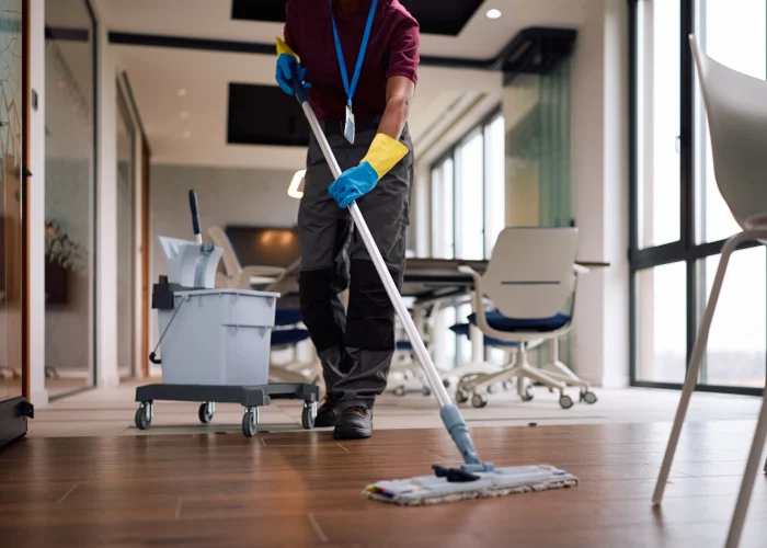 Gut geschulte Reinigungskraft reinigt den Boden in einem Büro